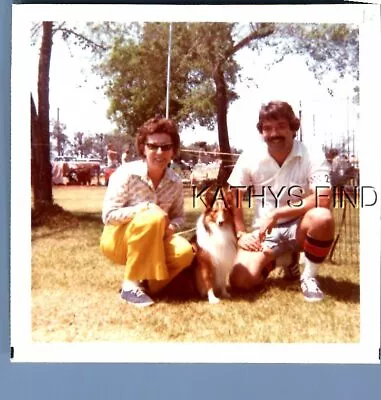 Found Color Photo H+6366 Man And Pretty Woman Posed Crouching By Dog • $6.98
